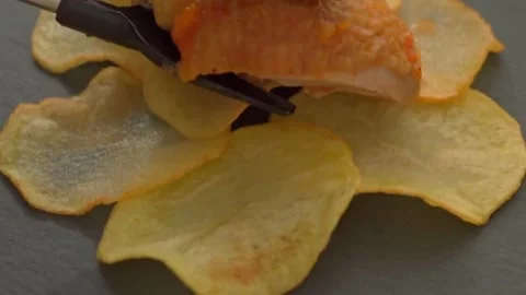 Chef placing Chicken Cacciatore (Italian chicken stew) arranged on potato chips Stock Footage 318850563