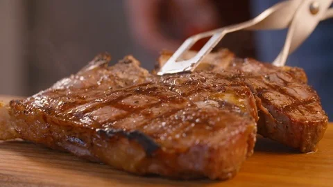 Chef placing the cooked meat to rest on the chopping board Stock Footage 86171290