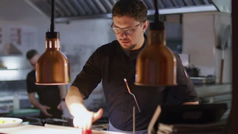 Chef Placing Finished Plate and Reading Order Ticket in Restaurant Kitchen Видео 330062405