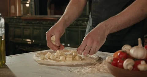 Chef placing pieces of mozzarella cheese on dough in the kitchen Stock Footage 201467785