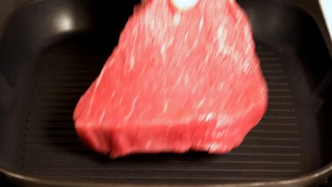 Chef placing raw beef steak into a hot griddle Video stock 105106372