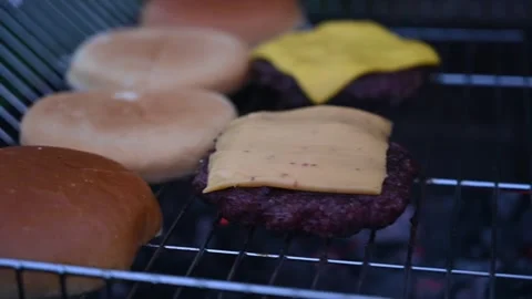 Chef placing slices of cheddar cheese on hamburger patties Vídeo Stock 286124559