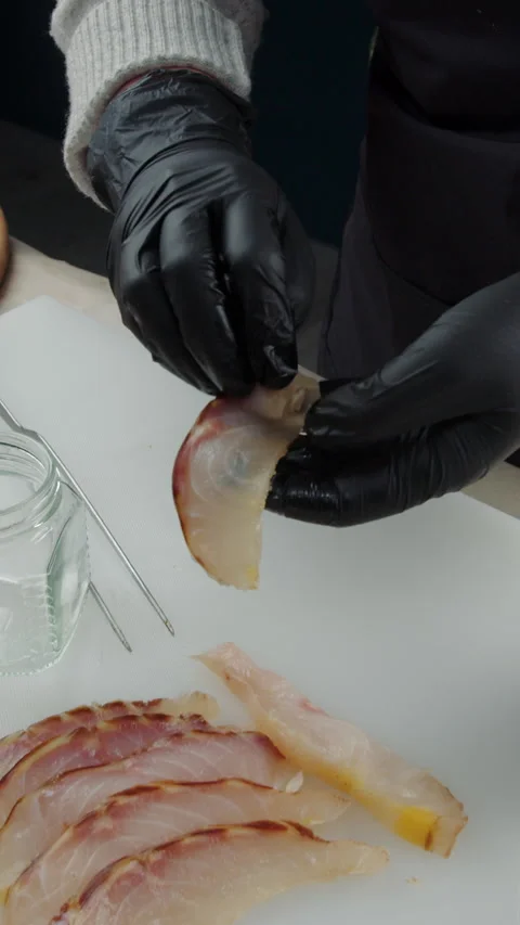 Chef placing smoked fish slice into glass jar Stock Footage 308354111