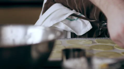 Chef placing thin slices of potato onto a tray in interior kitchen with soft day Stock Footage 199458677