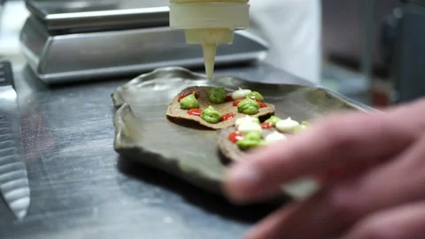Chef plates a Mexican inspired dish in a restaurant's kitchen 库存影片 203898630