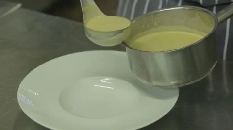 Chef plating up a bowl of soup in a restaurant kitchen Stock Footage 58432044