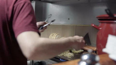Chef plating up a burger on hot plate Vídeos de archivo 126637654