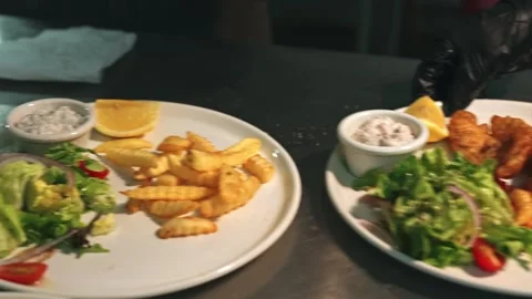 Chef Plating Crispy Battered Fish Fillets with French Fries and Salad Stock Footage 342219449