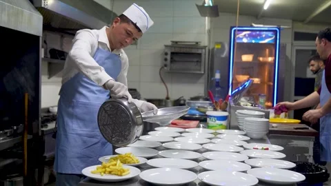 Chef plating french fries for multiple orders Izmir Turkey Dec 8, 2023 Stock Footage 332115786