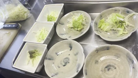 Chef Plating Fresh Green Salad Into Small Bowls In A Japanese Kitchen Stock-Footage 338320290