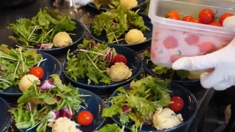 Chef Plating Fresh Side Salads with Cherry Tomatoes in Commercial Kitchen Video stock 347688392