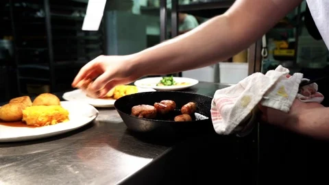 Chef plating up out of a saucepan Stock Footage 106810107