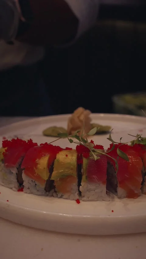 Chef plating rainbow sushi rolls with arugula garnish – 4K vertical video Stock Footage 315419169
