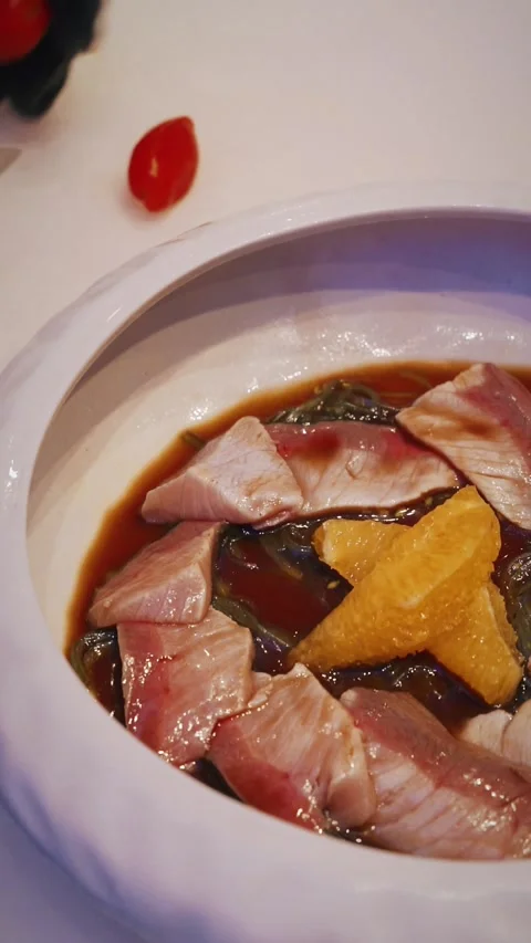 Chef plating red snapper sashimi with citrus garnish and tomatoes 4K vertical Stock Footage 315990508