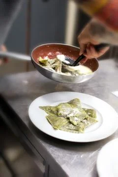 Chef plating up a serving of ravioli pasta Stock Photos