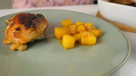 Chef plating serving roasted chicken thighs and potatoes from baking dish. Video stock 317174647