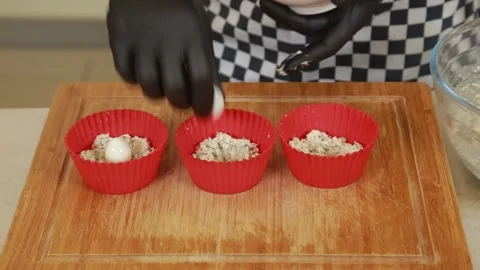 Chef portioning a prepared mixture into silicone molds for baking Stock Footage 340552471