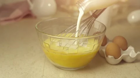 Chef pour milk onto whisked eggs Stock Footage 57319436