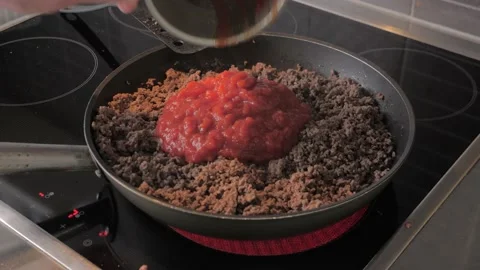 Chef pour in tomato sauce in minced meat in a frying pan Stock Footage 201594438