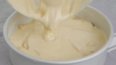 Chef pouring cake batter into a baking pan on the top of apple slices Stock Footage 232617565