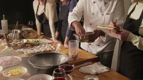 Chef Pouring Cashews Into Container, Students of Master Class Watching Process Stock Footage 332572732