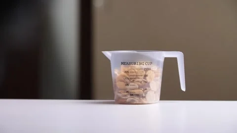 Chef pouring corn flakes into measuring cup on kitchen counter Vidéo 303370086