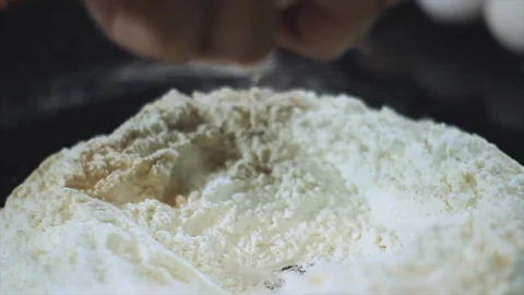 Chef pouring the egg over the flour to prepare the dough Stock Footage 100647679