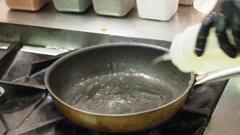 Chef pouring ghee and spices in hot pan to prepare indian food Stock Footage 304729613