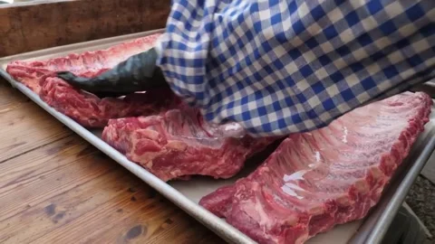 Chef Pouring Liquid Marinade Over Raw Pork Spare Ribs on Stainless Steel Tray fo Vídeos de archivo 332813370