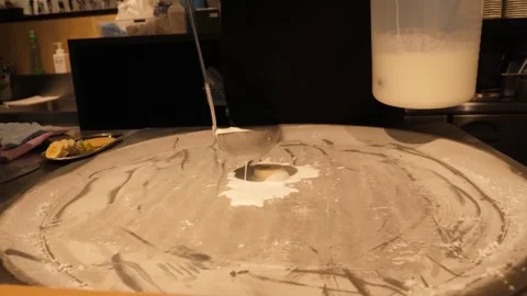 Chef Pouring Liquid Milk Base on Cold Plate to Prepare Rolled Ice Cream Stock Footage 345293186