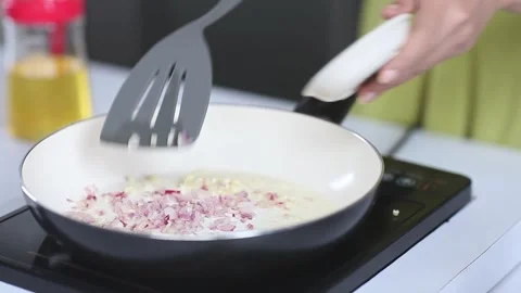 Chef Pouring Minced Red Onions into Ceramic Pan for Sautéing Vídeo Stock 334915734