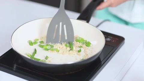Chef Pouring Minced Red Onions into Ceramic Pan for Sautéing Stock-Footage 334915803