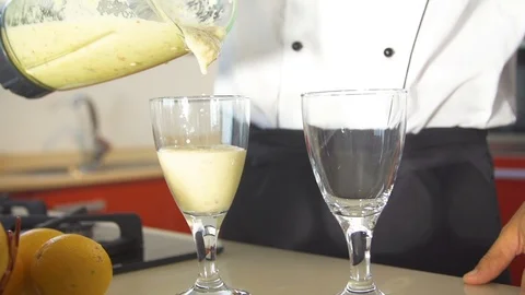 Chef pouring mixed fruit juice into glass in kitchen Stock Footage 85814833