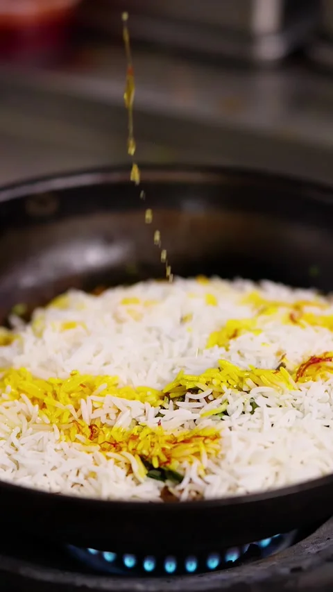 Chef Pouring Saffron Oil Over Basmati Rice in Commercial Kitchen Stock Footage 337917943