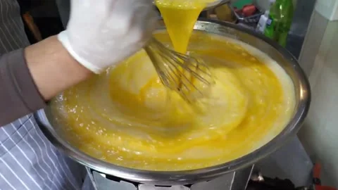 Chef Pouring Whisked Eggs into Large Pot in Commercial Kitchen 스톡 동영상 343587490
