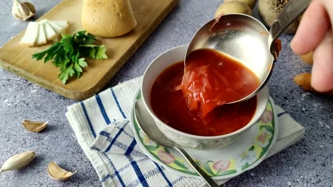 The chef pours borscht into a white plate Stock Footage 225480211