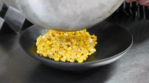Chef pours cooked corn in a dish 库存影片 203897220