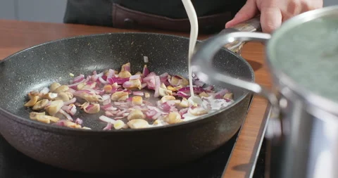 Chef pours cream into fried onion and mushrooms. Creamy champignon pasta Stock Footage 254698085