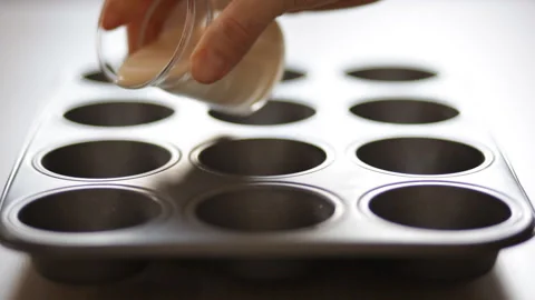 The chef pours the dough into baking pans. Yorkshire puddings. Close-up. Video stock 106268225