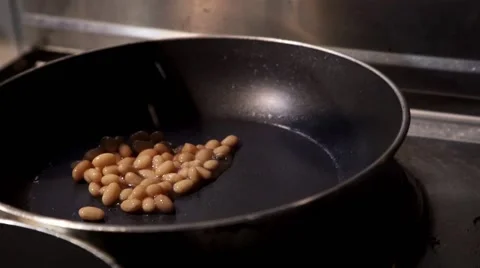Chef pours kidney beans to a hot pan Stock Footage 61559908