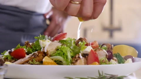 Chef pours lemon juice on salad of fresh vegetables. Cooking delicious salad Stock Footage 139779659