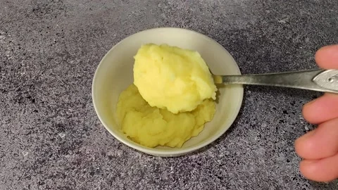 The chef pours mashed potatoes into a plate using a spoon Stock Footage 230015414