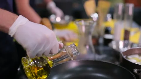 Chef pours oil in a frying pan Stock Footage