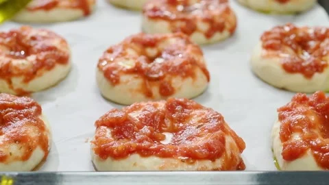 The chef pours olive oil on  the mini pizzas. Stock Footage 210718227