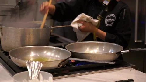 Chef pours olive oil in a pan Stock Footage 222834541
