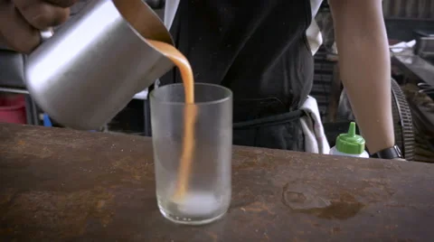 A chef pours an orange drink into a cool glass and serves it to the camera Stock Footage 58744905