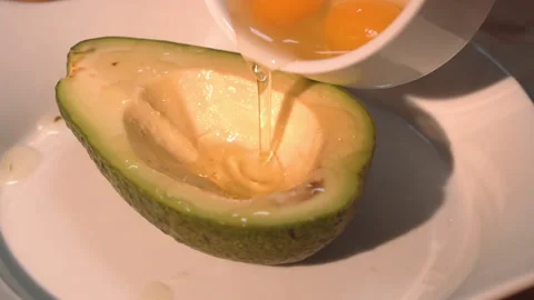 The chef pours quail eggs into half an avocado Stock Footage 158021878