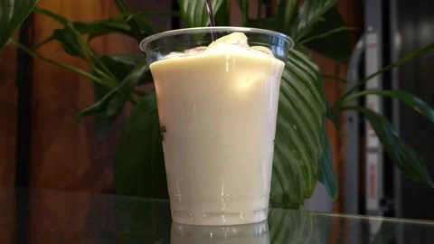 The chef pours raspberry syrup into coconut milt ice on a green background of Stock Footage 161603441