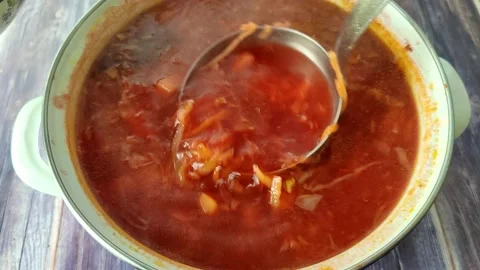 The chef pours red borscht into a plate Stock Footage 230015096