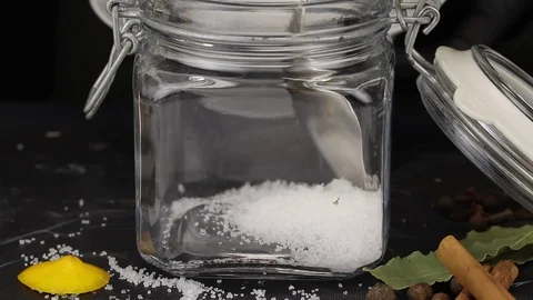 Chef pours salt into a rectangular glass jar Stock Footage 123080293